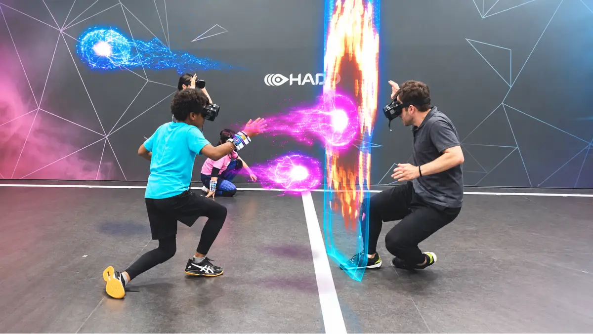 A child landing a hit on an adult opponent during a HADO match