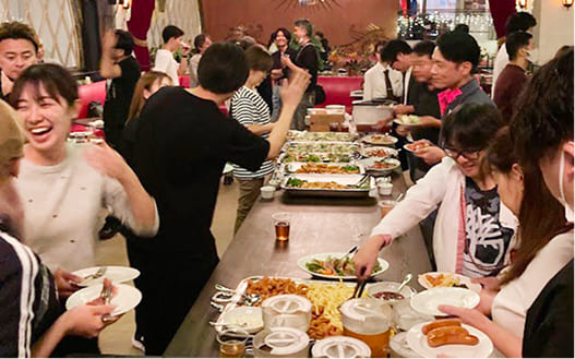 社員同士がお台場の会場で立食パーティーを楽しんでいる様子